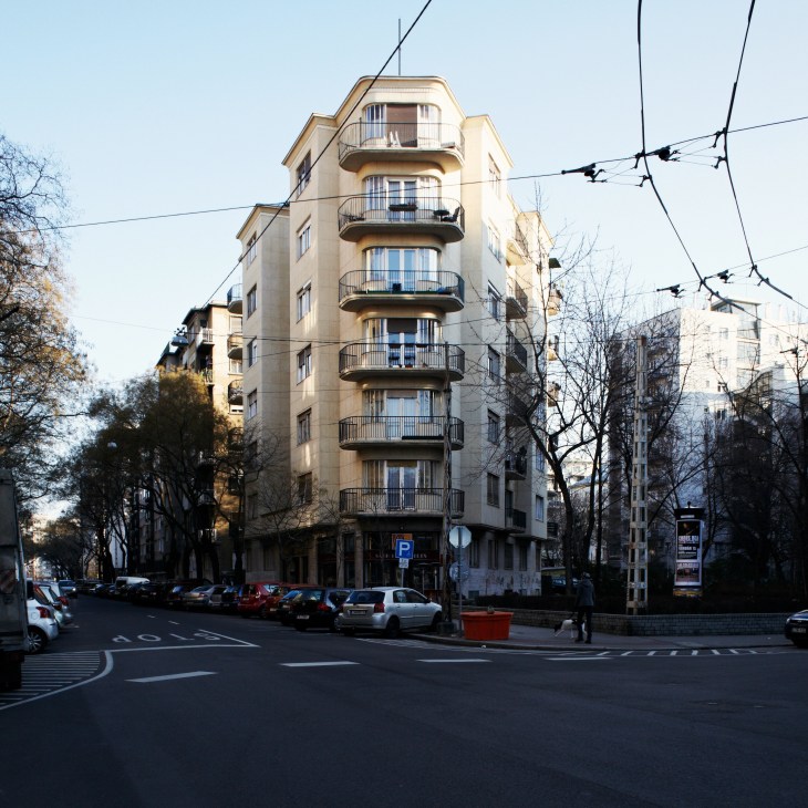 Art deco building on Pozsonyi Road with curved balconies and cream-colored facade in Budapest.