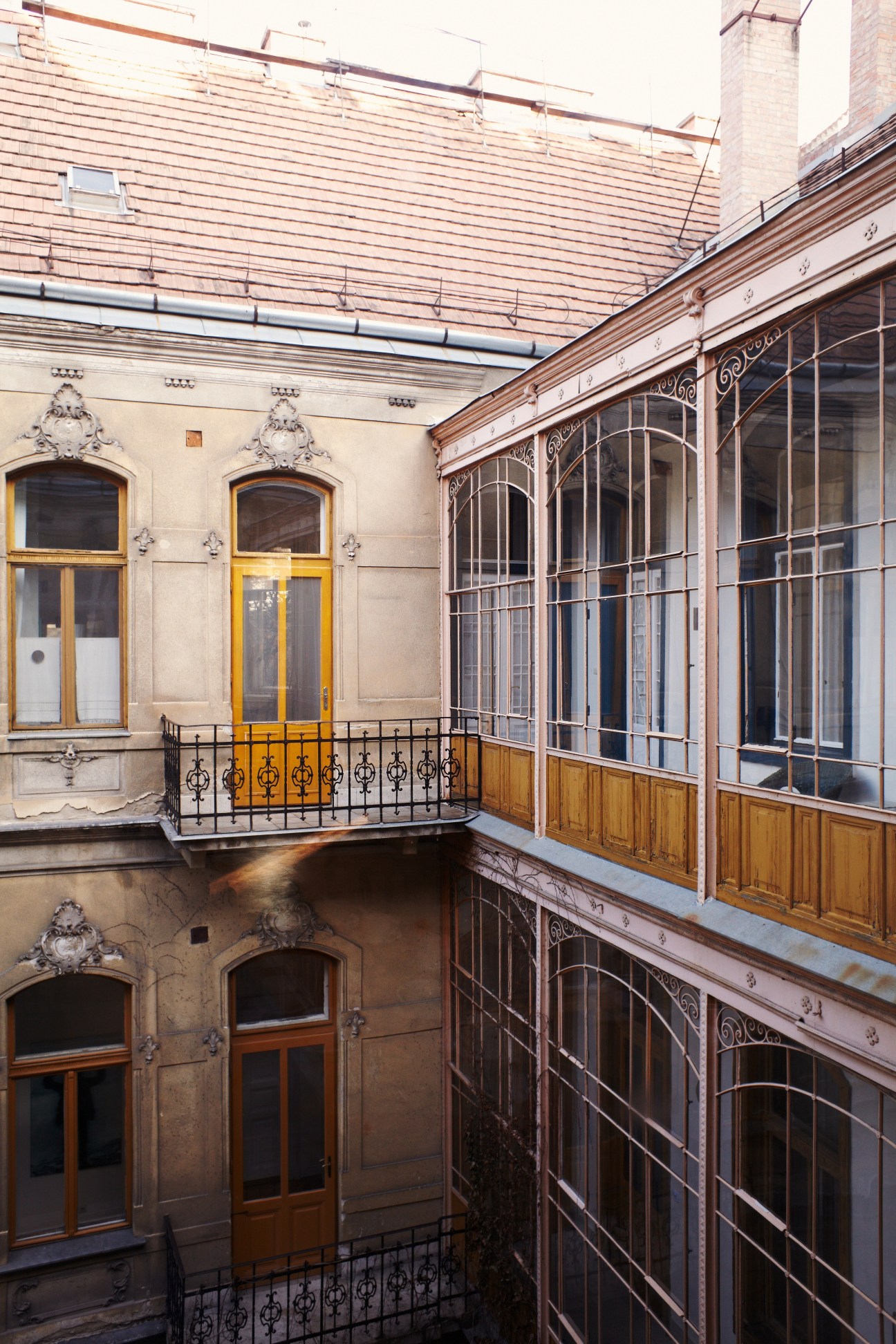 Courtyard of Brody House hotel showing ornate period architecture with yellow door and wrought-iron balconies.