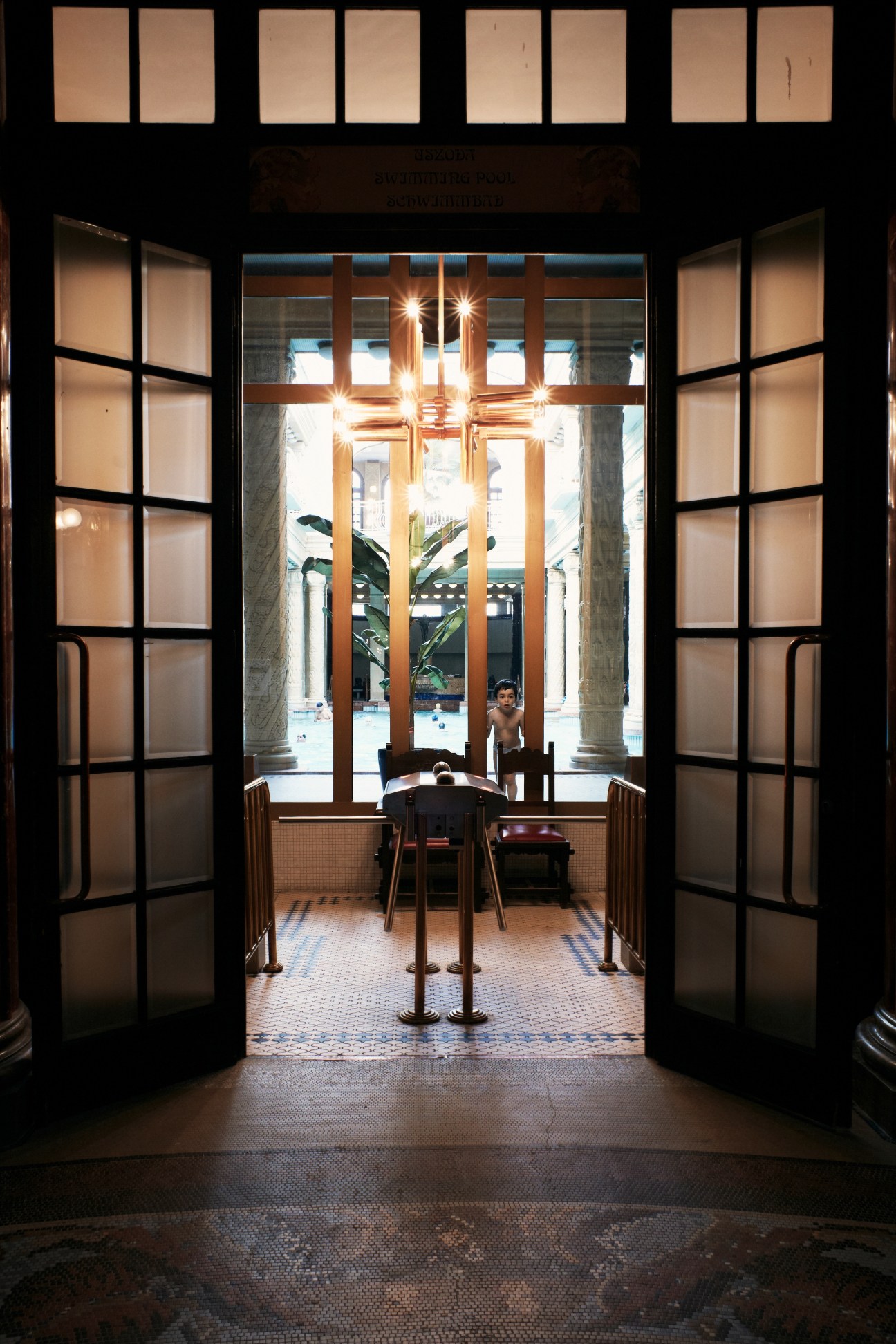 Interior view of early 20th-century Gellert Baths with ornate wooden doors and Art Deco fixtures.