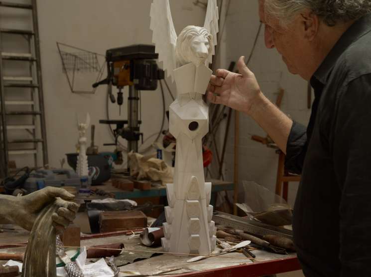 Sculptor Xavier Medina Campeny works on an ornate white stone carving in his workshop studio.