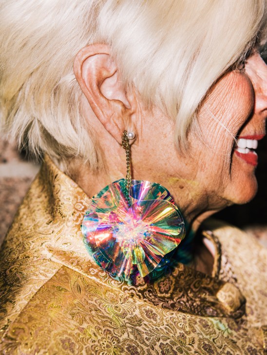 Close-up of a woman wearing a colorful iridescent heart-shaped earring at Modernism Week opening-night gala.