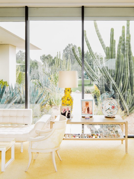 Mid-century modern bedroom at Sunnylands with floor-to-ceiling windows overlooking desert cacti and mountains.