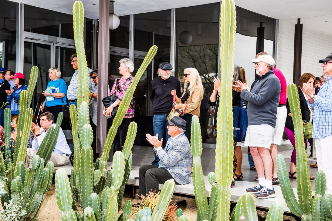 Crowd gathered outside modern building with cacti during John Lautner plaque unveiling ceremony.