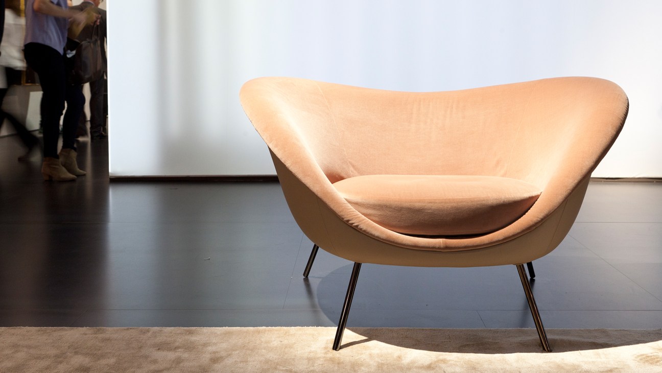 Gio Ponti D.154.2 armchair upholstered in beige fabric with curved organic form and thin metal legs.