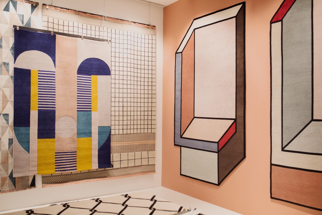 Colorful geometric rugs and wall hangings displayed at the CC Tapis stand at IMM Cologne.
