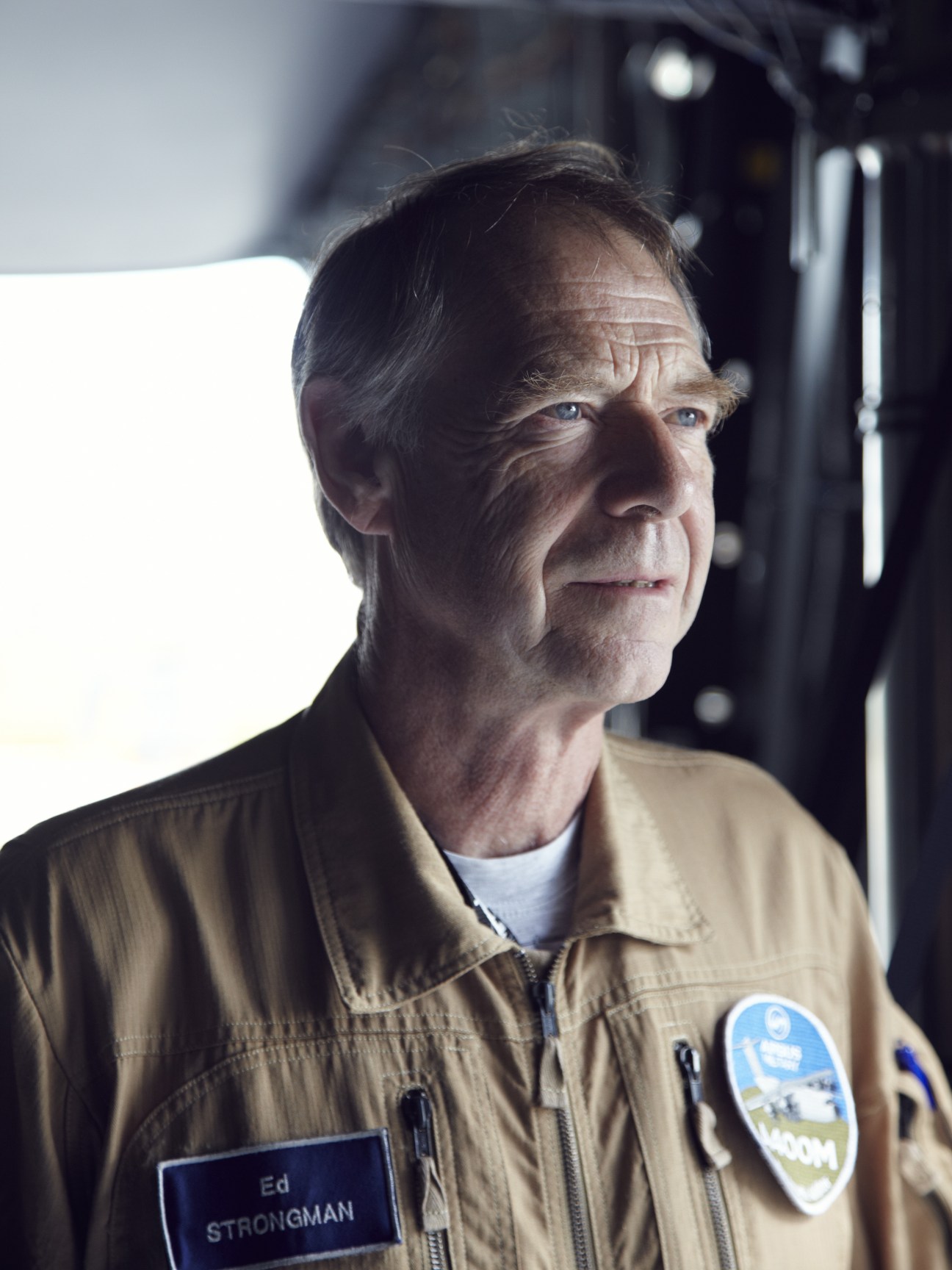 Ed Strongman, chief test pilot for Airbus, wearing a tan flight suit with name badge and patch inside an aircraft.