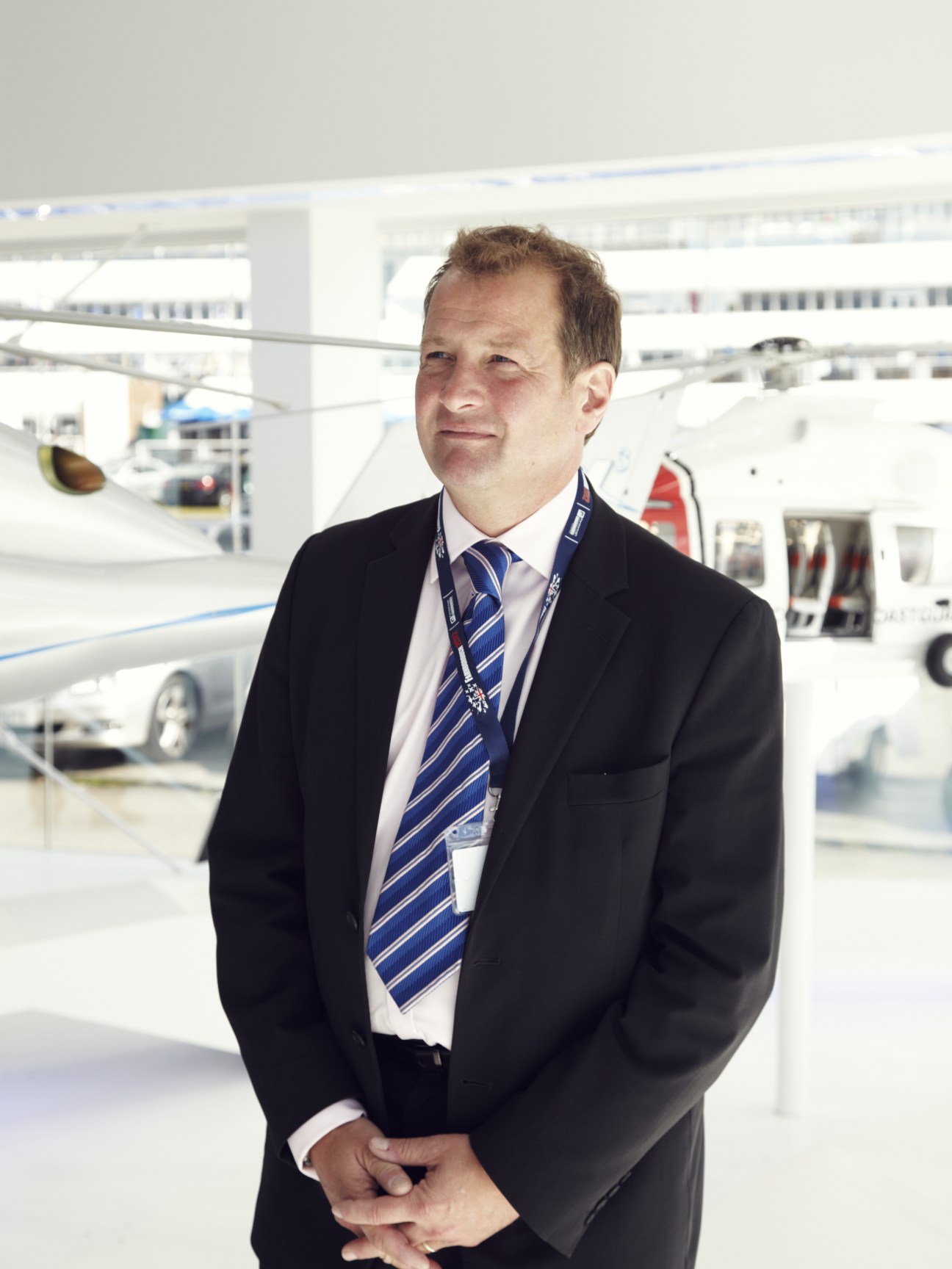 Shaun Ormrod, CEO of Farnborough International, stands in business attire at an aircraft hangar.