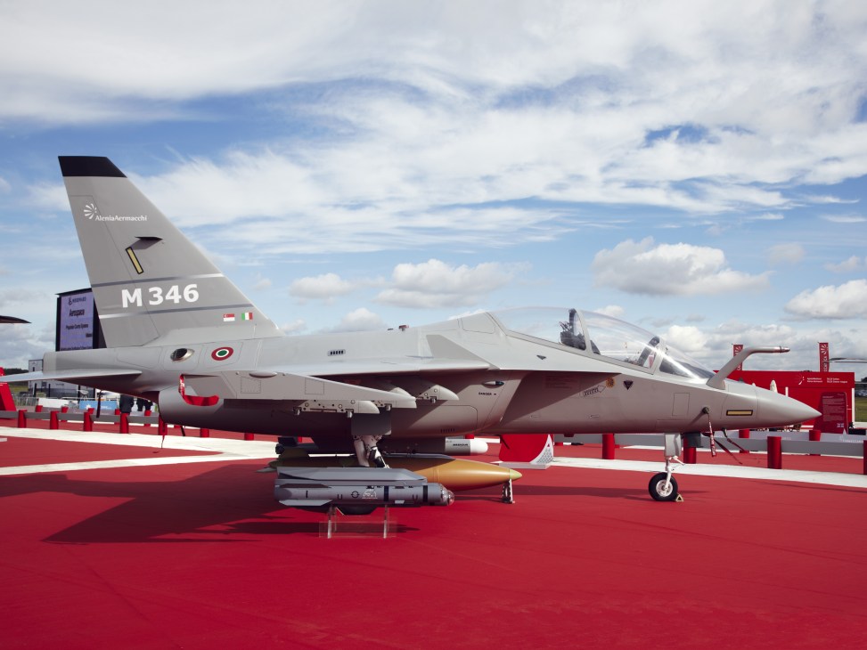 Alenia Aermacchi M346 trainer aircraft displayed on red carpet at air show.