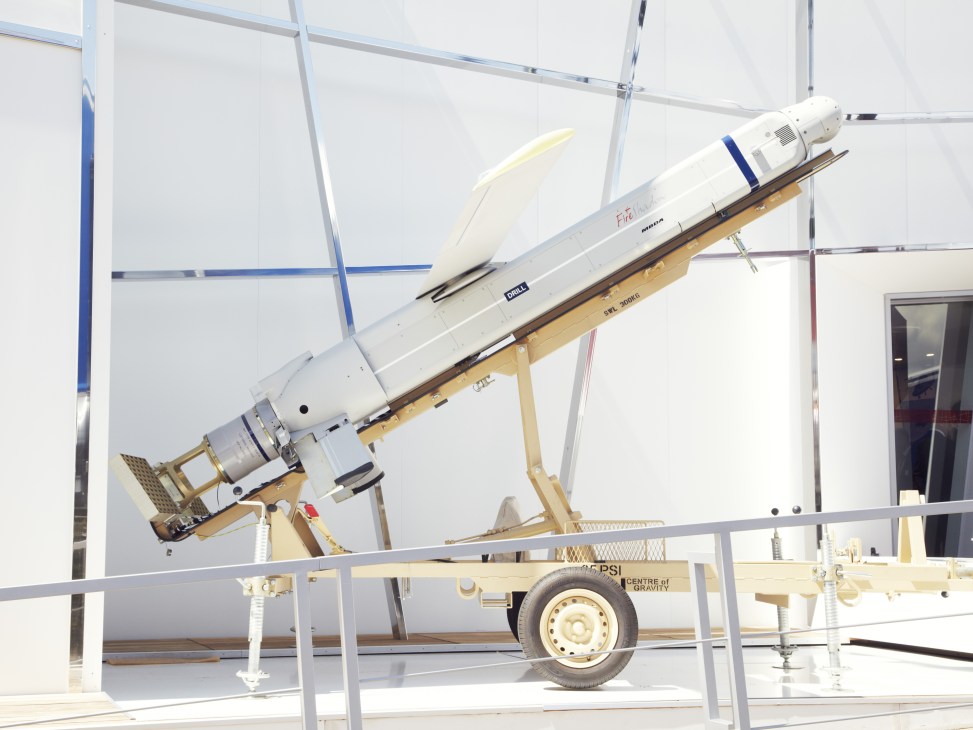 Fire Shadow surface missile displayed on a wooden launch platform inside a white exhibition tent.