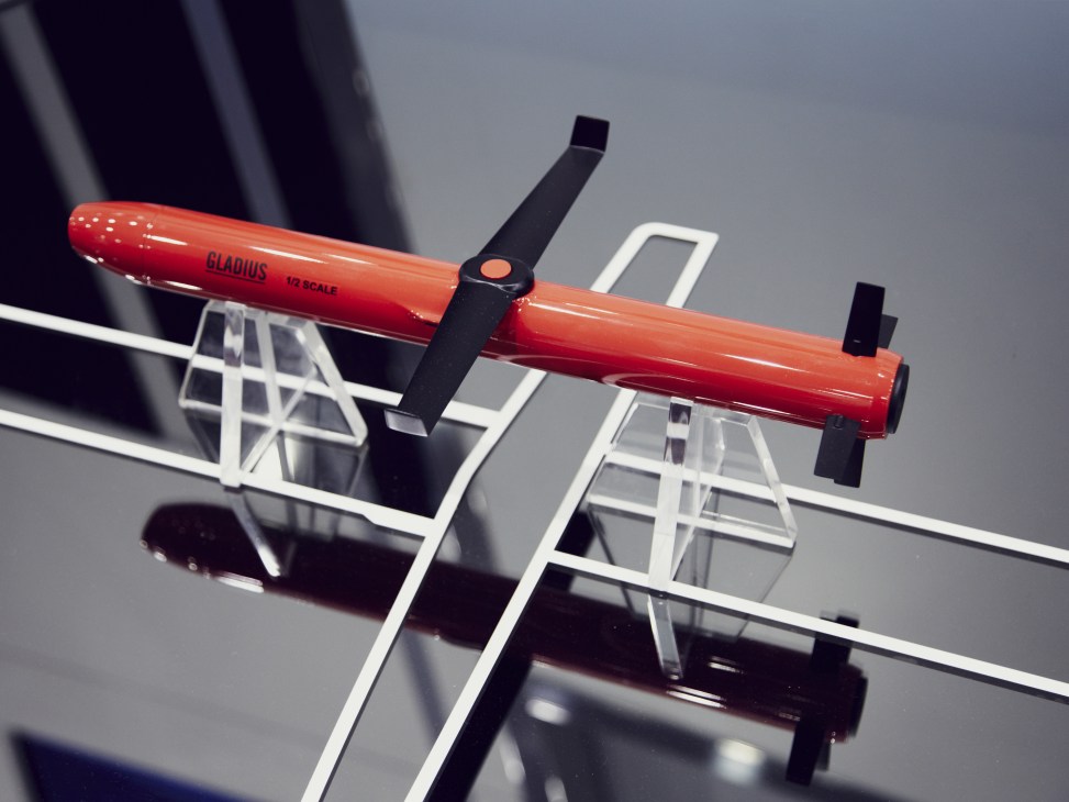Red-painted Gladius weapon model displayed on white stand at air show exhibition.