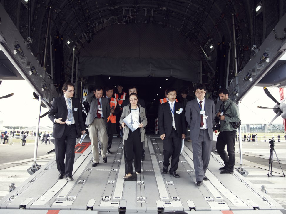 International delegates exiting the cargo hold of an Airbus A400M Atlas military transport aircraft.