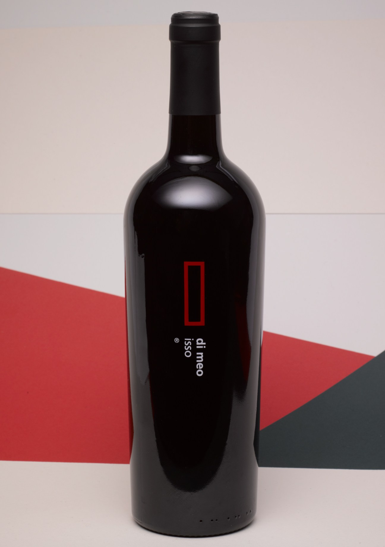 Di Meo Isso wine bottle with black label and red geometric logo on red and grey background.