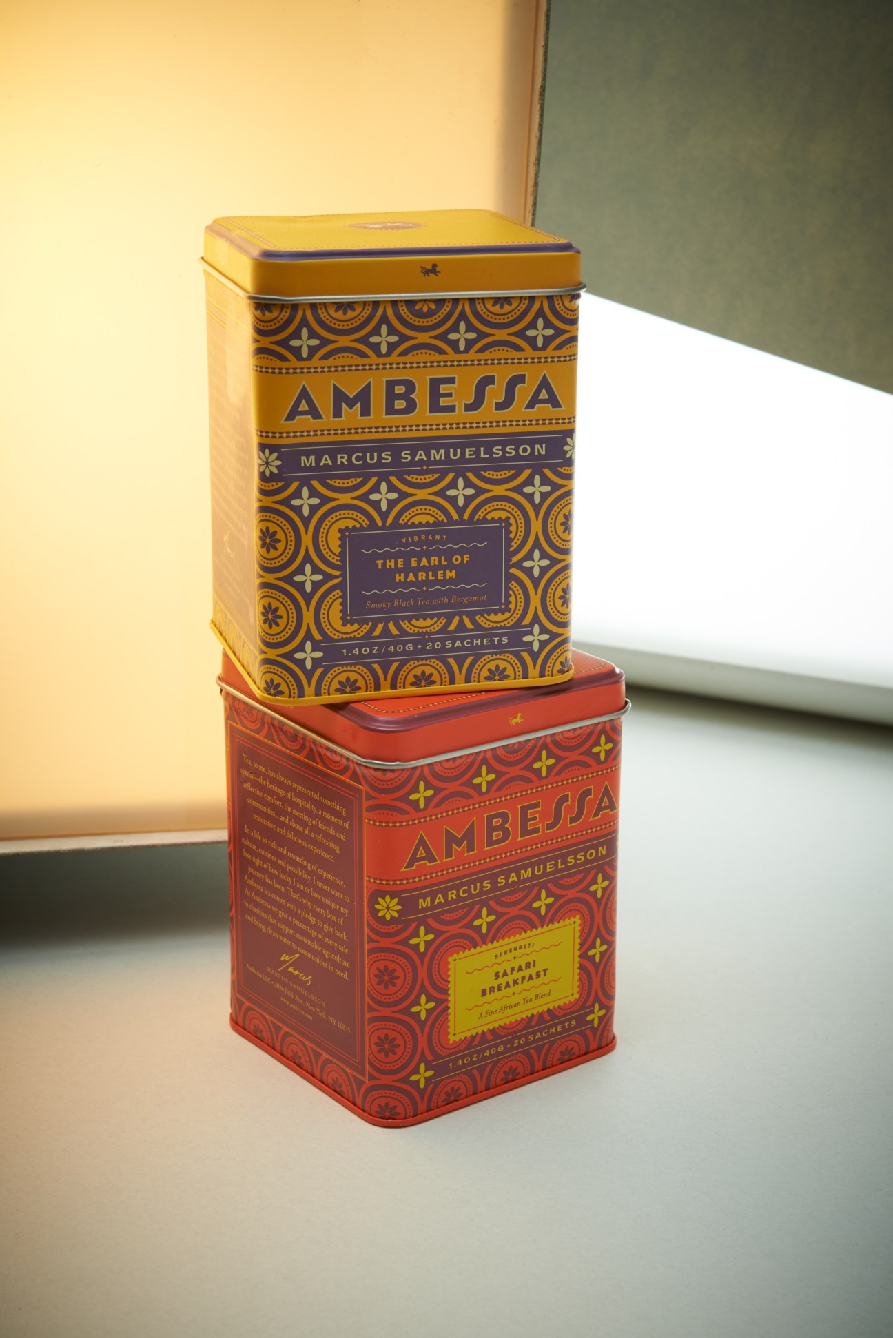Two stacked Ambessa tea tins by Marcus Samuelsson with gold and red decorative packaging.