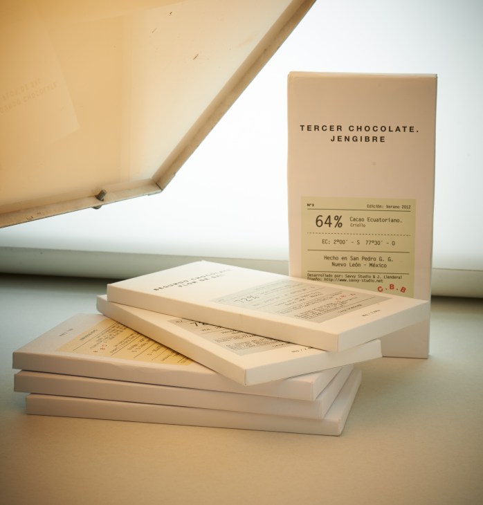 Casa Bosques chocolate bars with cream-colored packaging and stacked open boxes displaying flavor details.