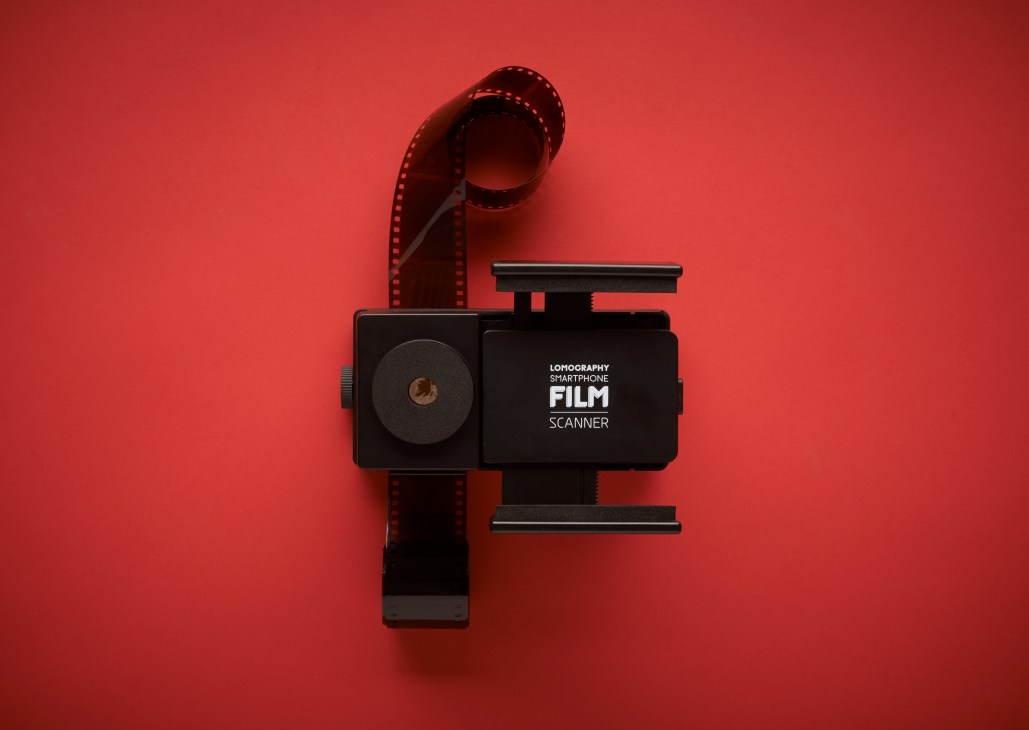 Lomography Film Scanner smartphone attachment with 35mm film on red background