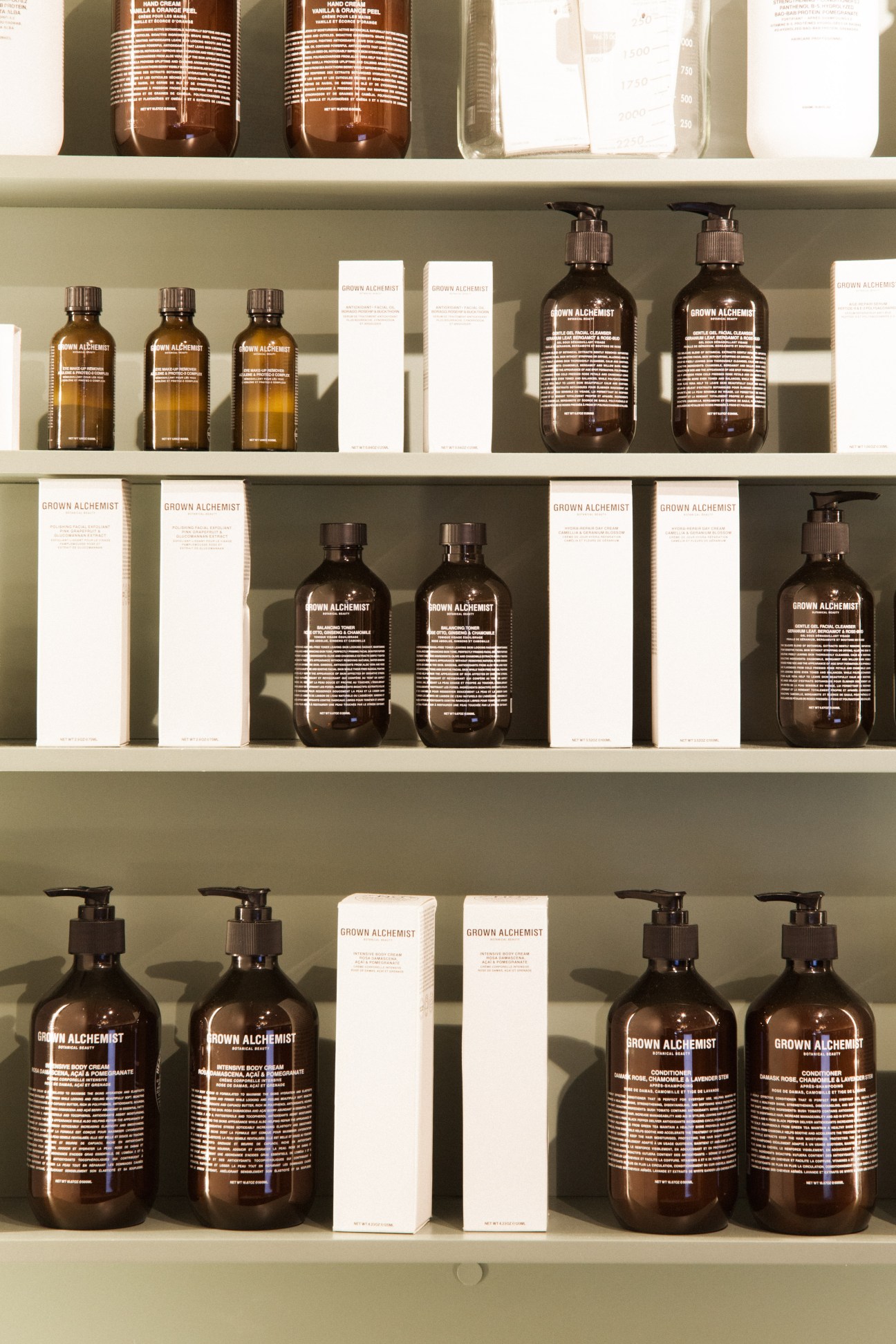 Shelves displaying Brown Alchemist cosmetic products in amber glass bottles with white packaging boxes.