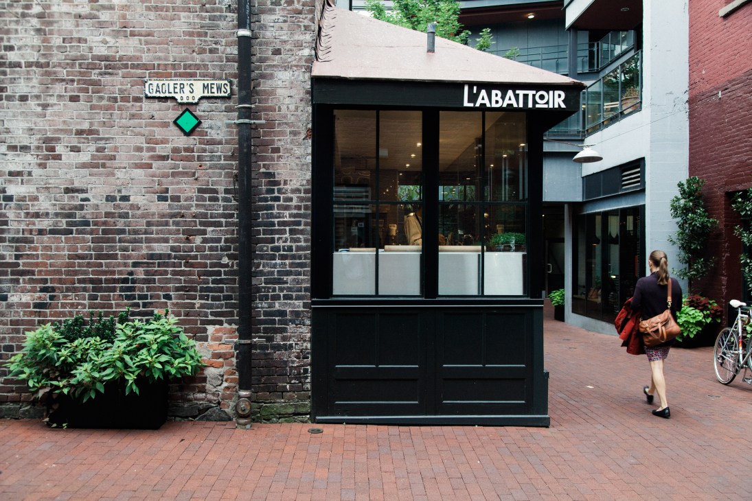 L'Abattoir restaurant storefront in Gastown with brick facade and black signage.
