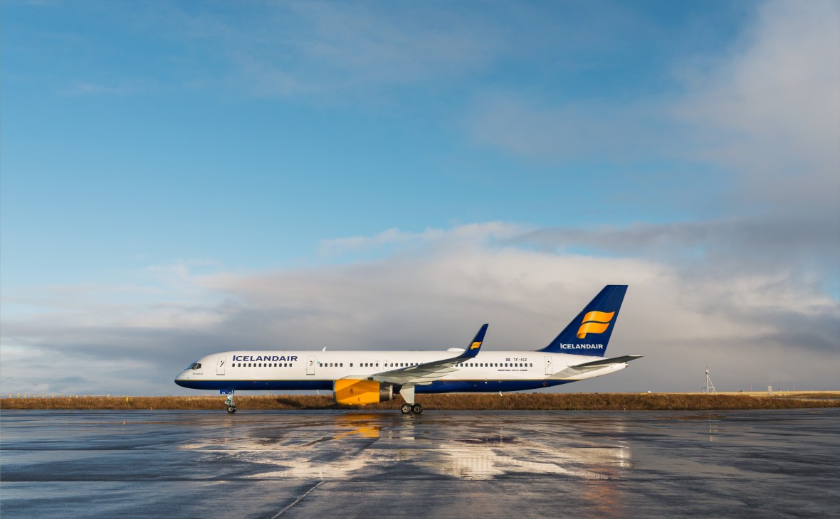 Icelandair Boeing 757 with white fuselage and blue and gold tail livery parked on runway at Keflavík International Airport.