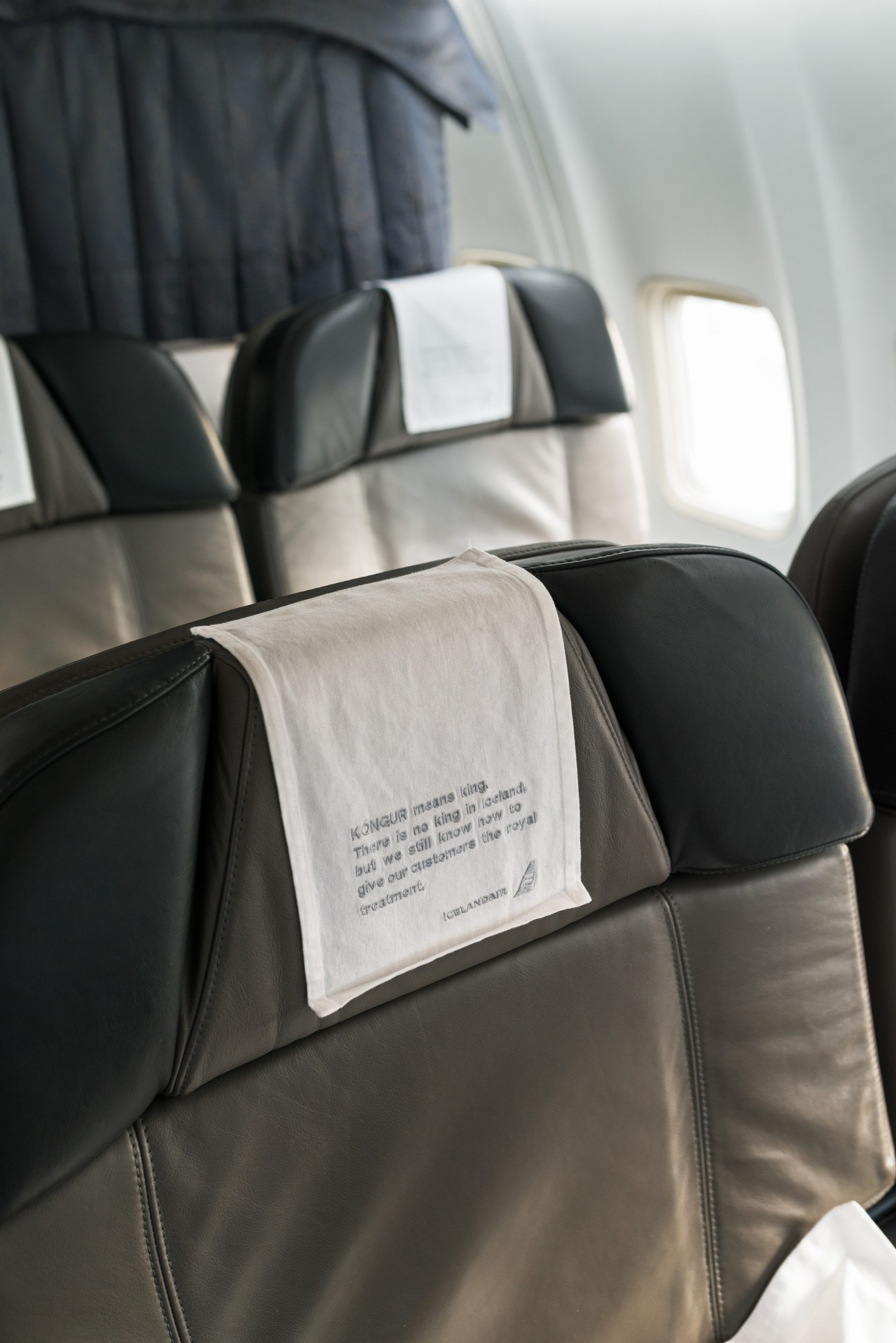 Icelandair Saga Class seats with white headrest covers displaying Icelandic text and branding.