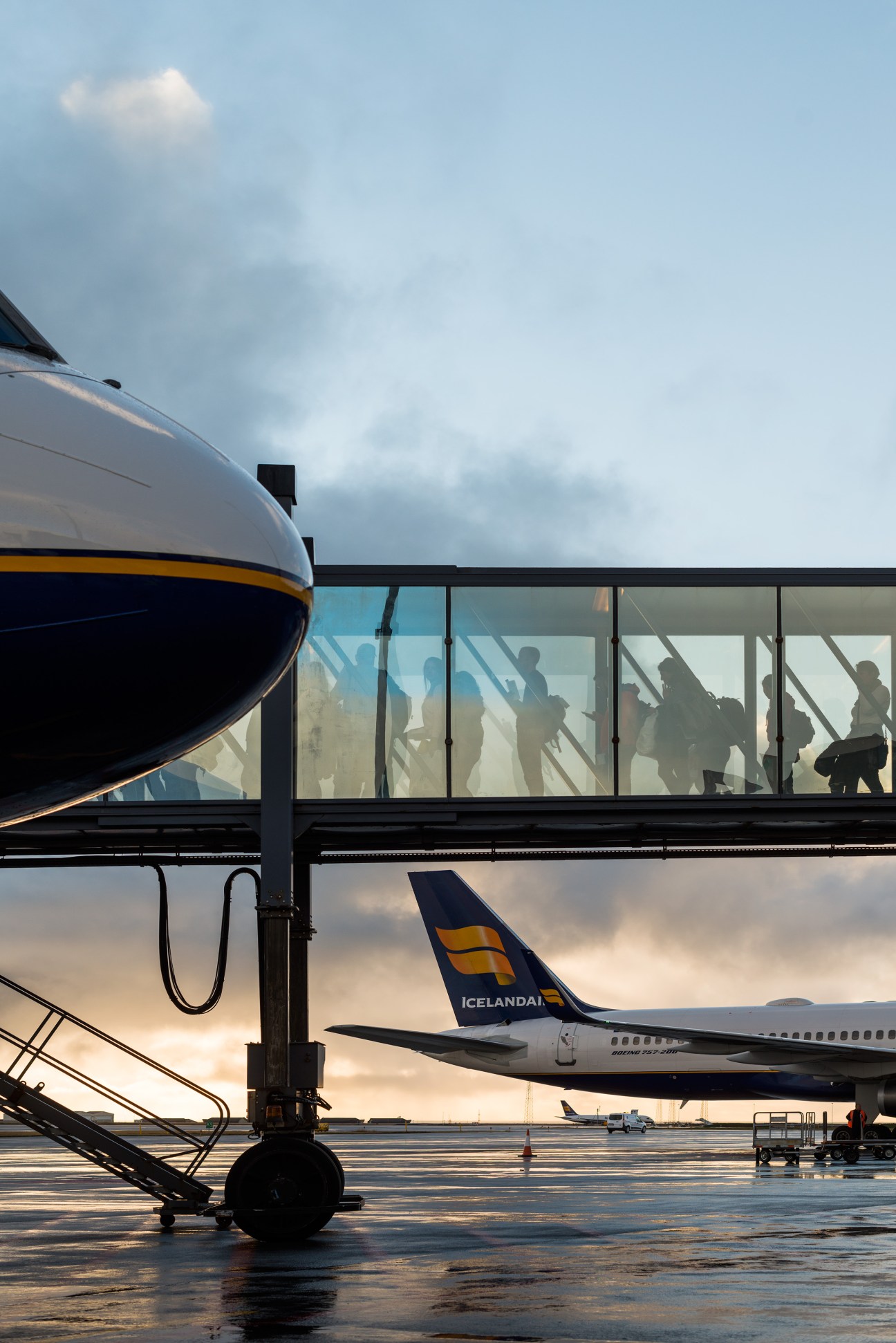 Passengers boarding an Icelandair aircraft at Keflavík International Airport through jet bridge.