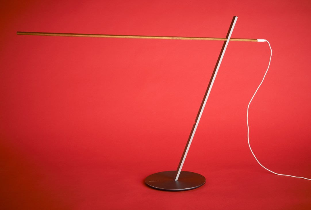 Pegacasa p-005 minimalist lamp made from bamboo with white neon tubing against red background.