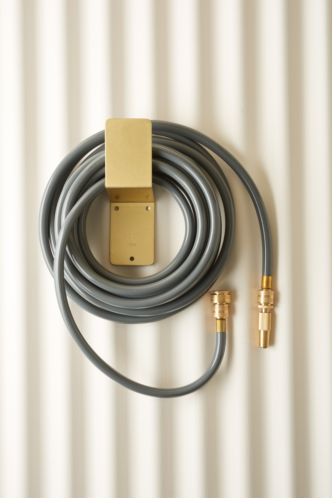 Lepaar garden hose with brass fittings and slate-coloured recycled rubber tube coiled neatly.
