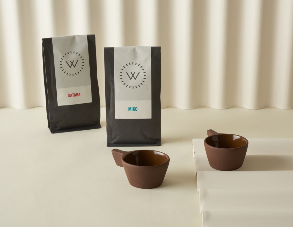 Workshop Coffee beans in black packaging with white labels and brown ceramic cups