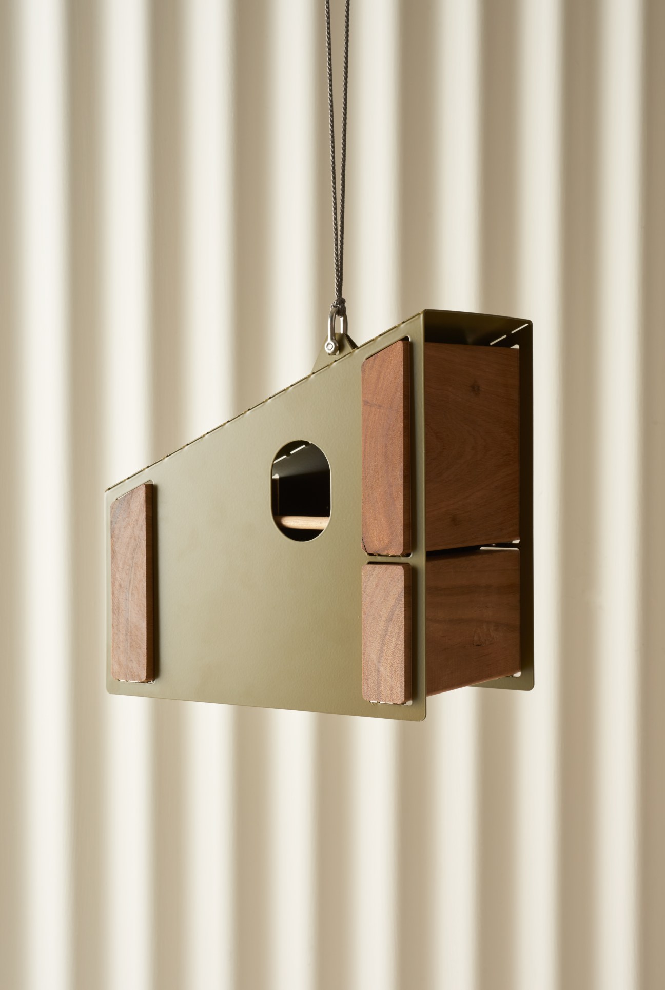 Tait Birdcabin hanging against a striped white background, showing timber and steel construction with small entrance hole.