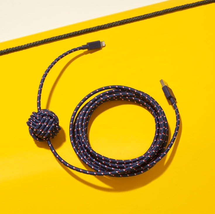 Native Union phone charging cable with nautical motif coiled on yellow background.