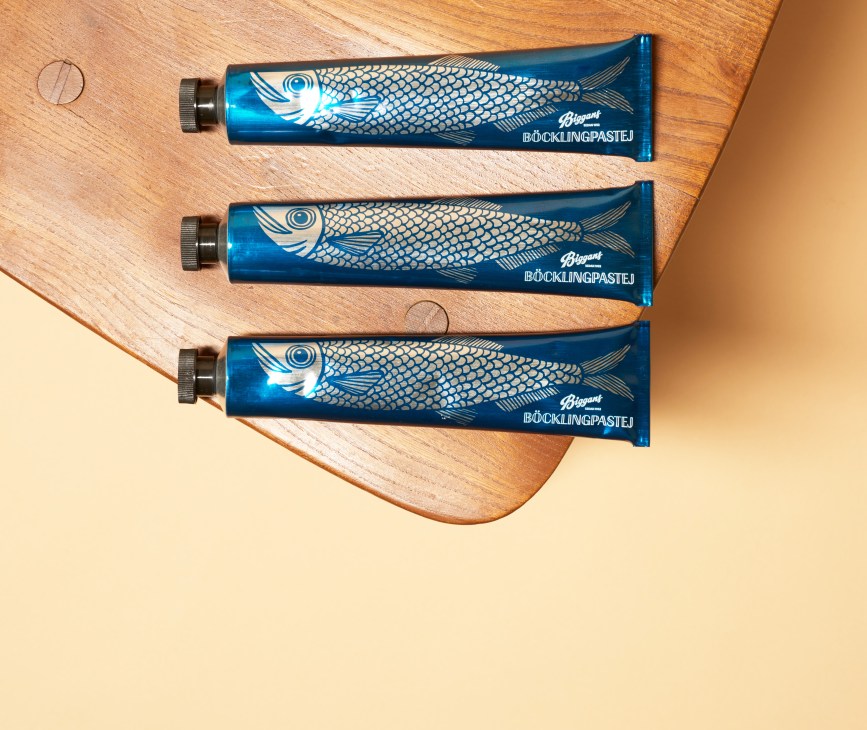 Three blue tubes of Biggans böcklingpastej (smoked herring paste) with fish illustrations arranged on a wooden surface.