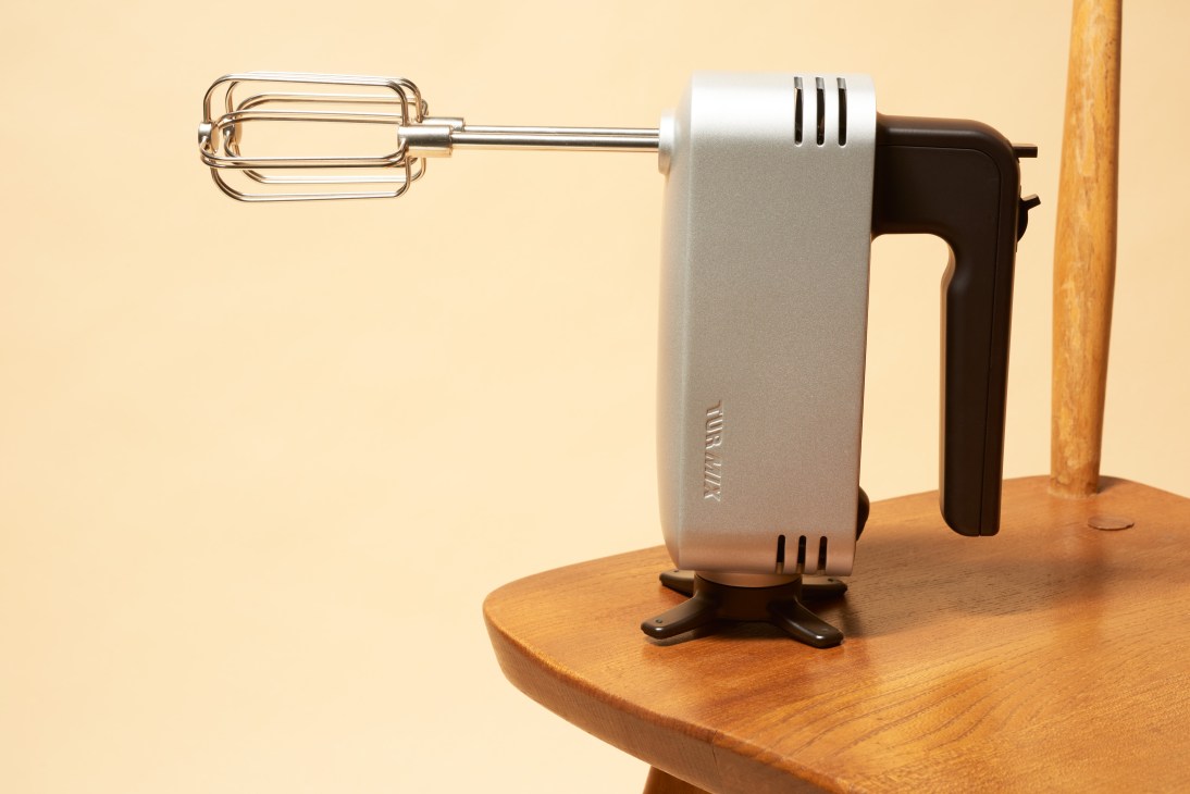 Turmix hand-mixer with steel whisk attachment and matte handle on wooden surface.