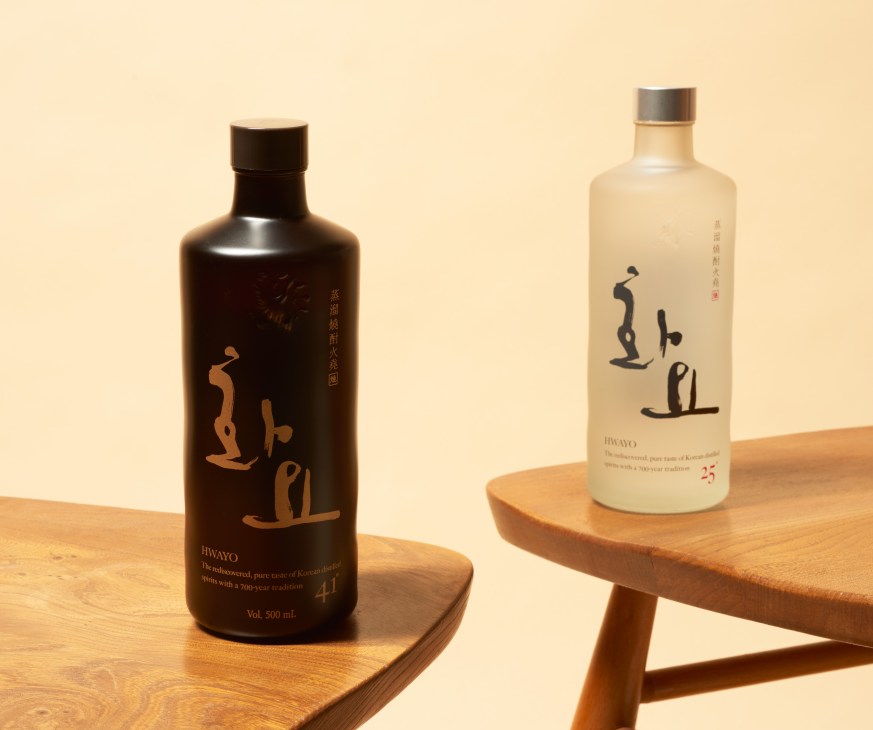 Two bottles of Hwayo soju on wooden platforms against a cream background.