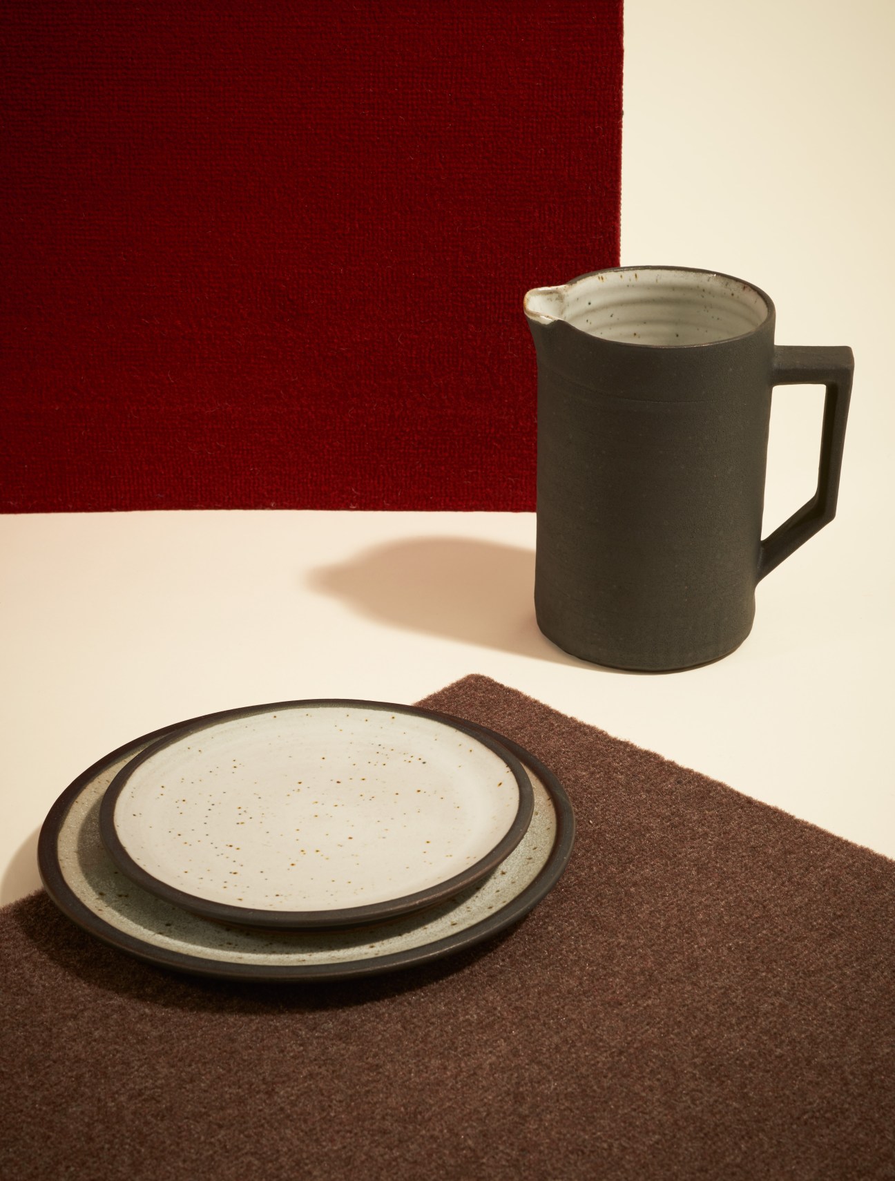 Herriott Grace ceramic tableware featuring speckled pitcher and plates with textured matte finish