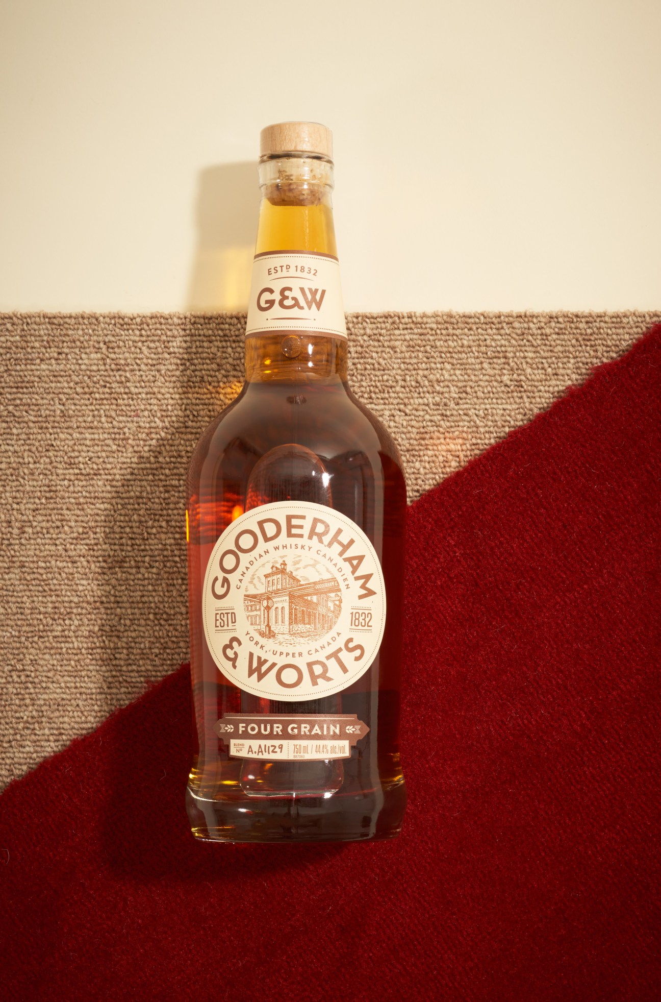 Gooderham & Worts Four Grain whiskey bottle with cork stopper on neutral background
