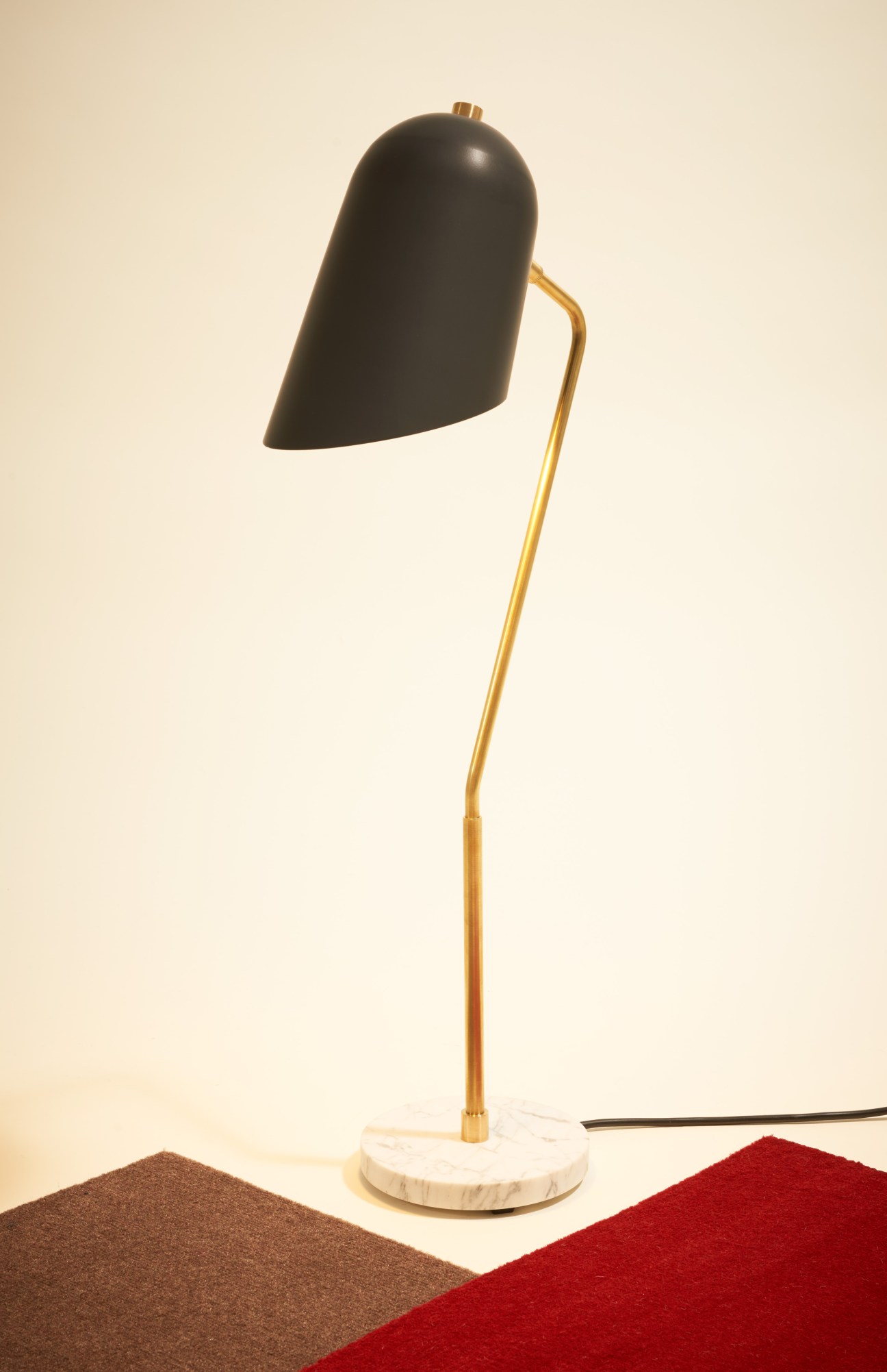 Modern desk lamp with black dome shade, brass stem, and white marble base