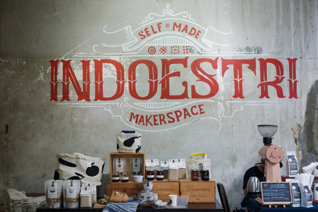 Indoestri makerspace storefront with red signage and displayed products including coffee bags and equipment.