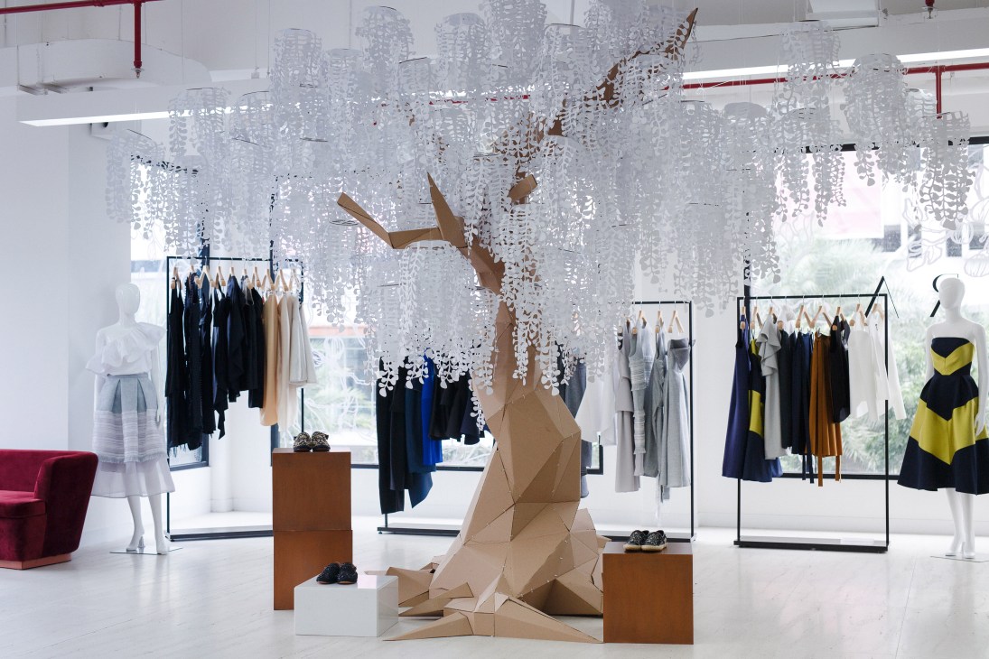 Interior of Ara fashion boutique showing clothing racks, mannequins, and decorative hanging installations.