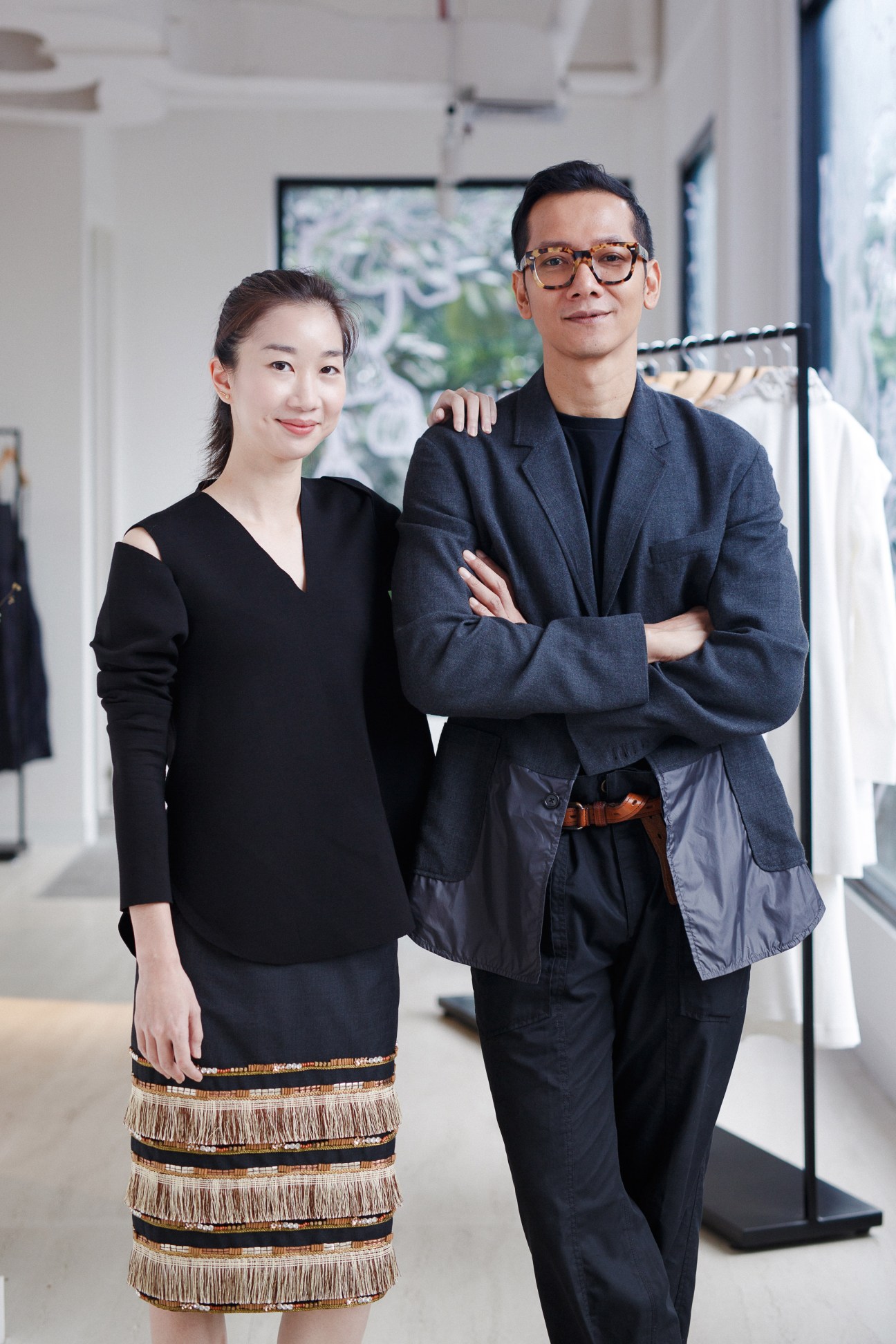 Fashion designer Toton Januar and Jo Elaine, founders of Ara fashion boutique, standing together in their minimalist shop space.