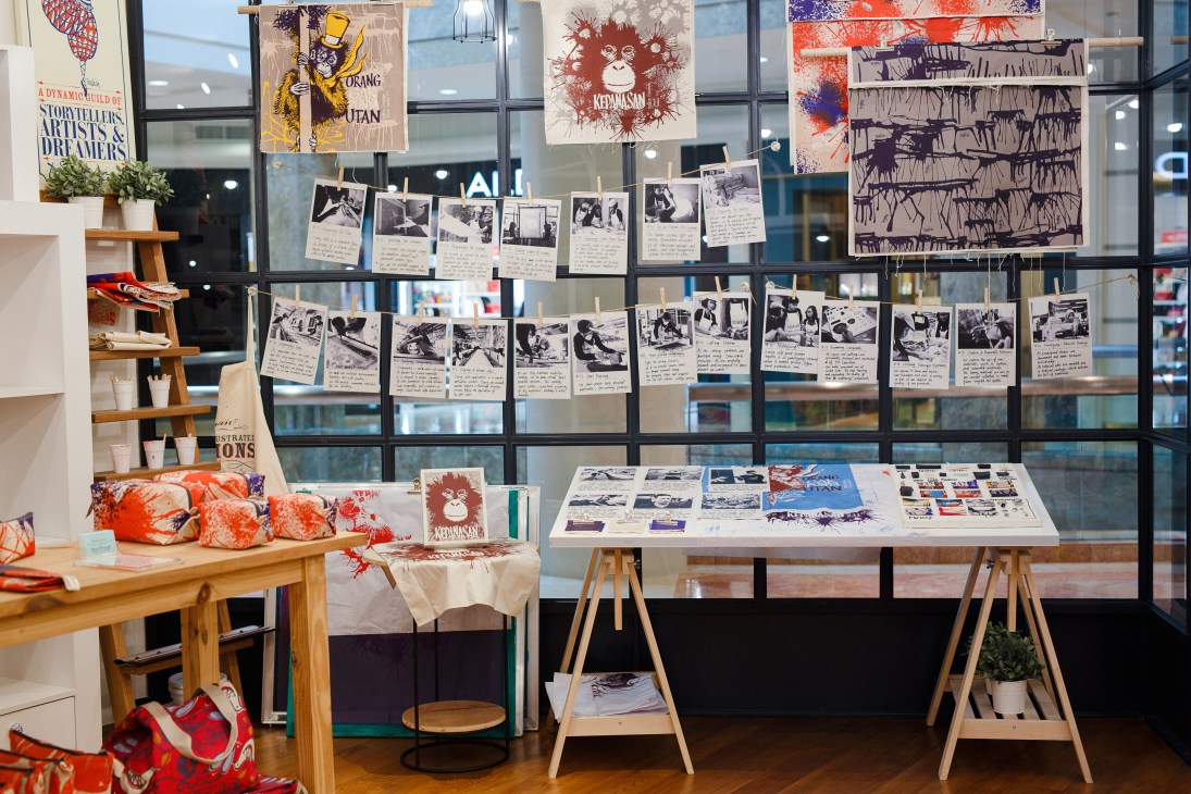 Tulisan boutique display featuring colorful textile products, photographs, and artwork on walls and tables.