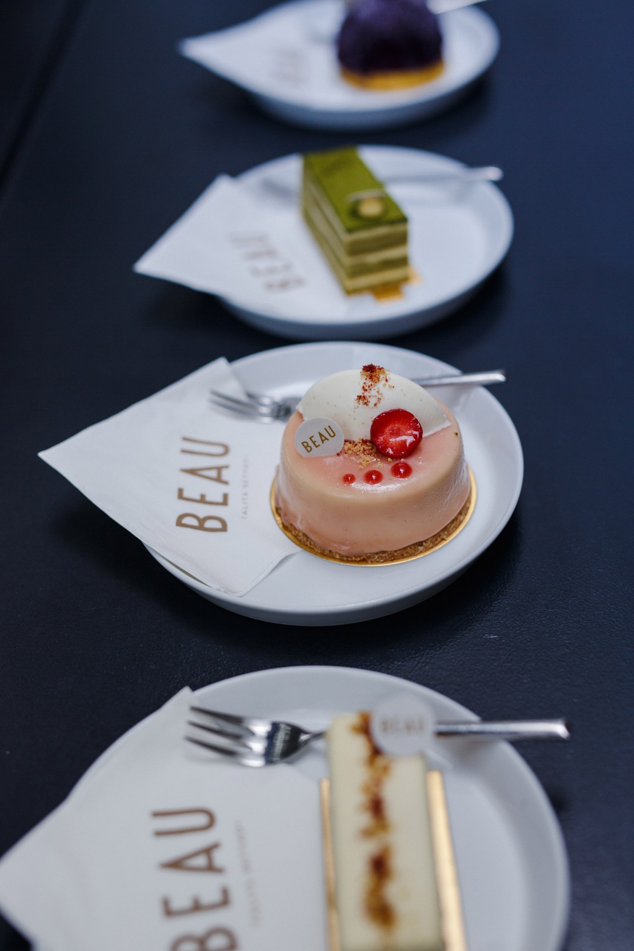Beau pastries and desserts displayed on white plates with the Beau logo.