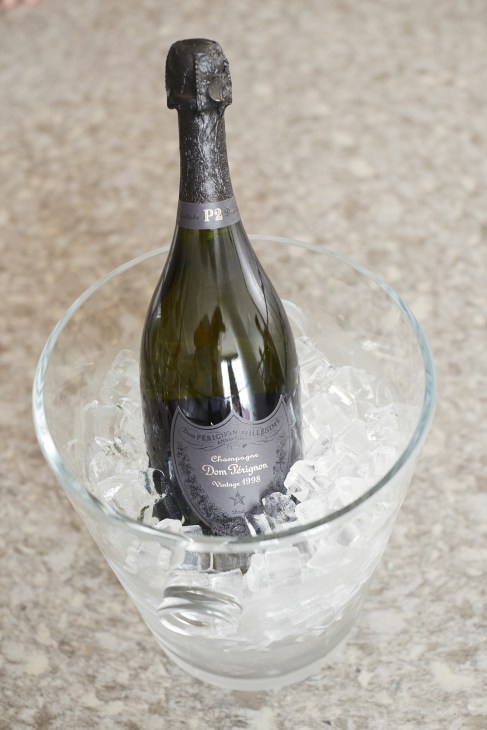 Dom Pérignon P2-1998 champagne bottle chilling in an ice bucket.