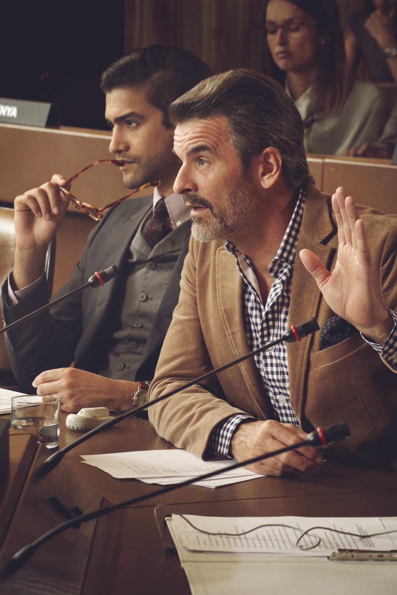 Two men in business attire seated at a conference table with microphones during a UN General Assembly session.