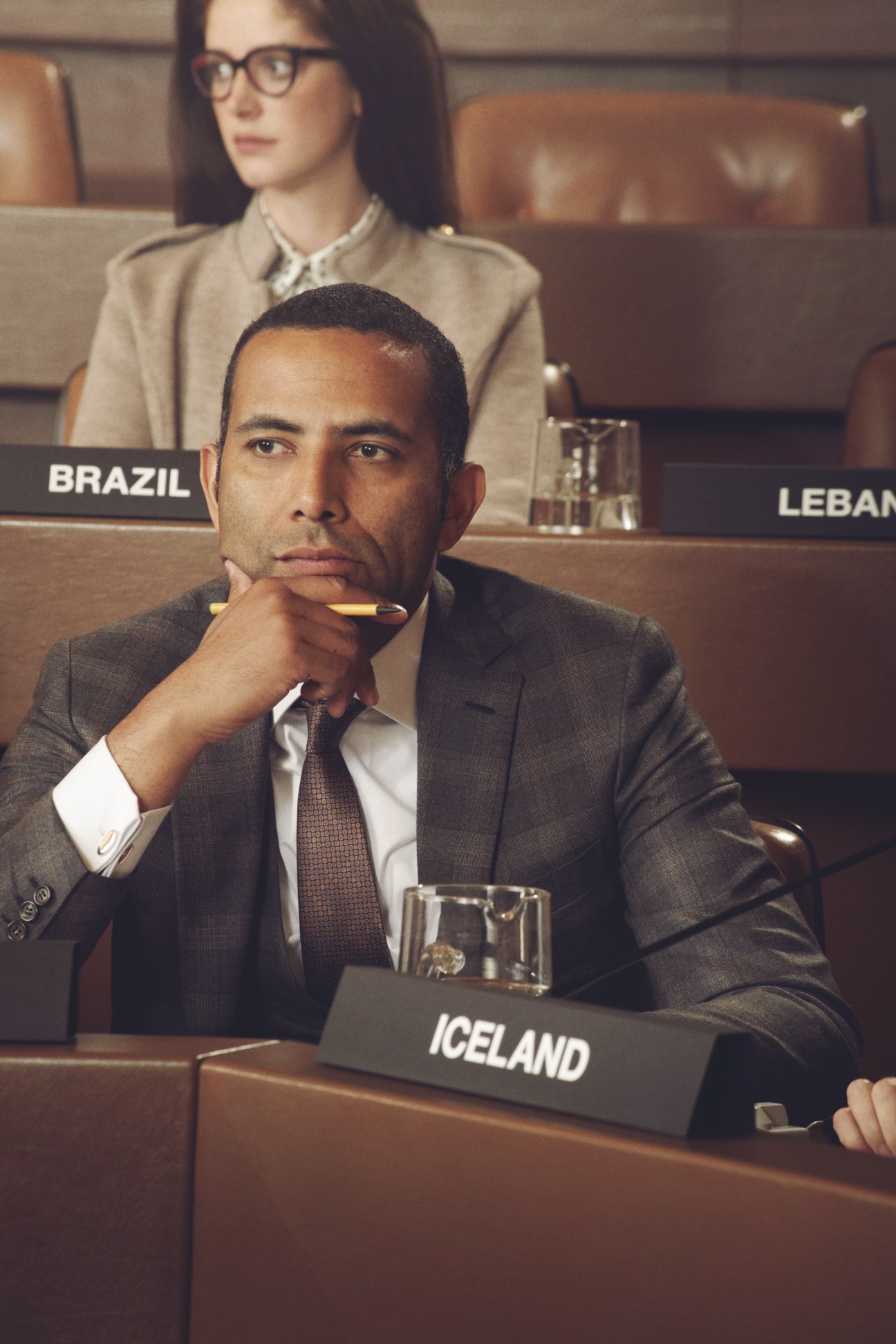 Male diplomat in dark suit at UN Assembly desk labeled Iceland with female delegate behind him.