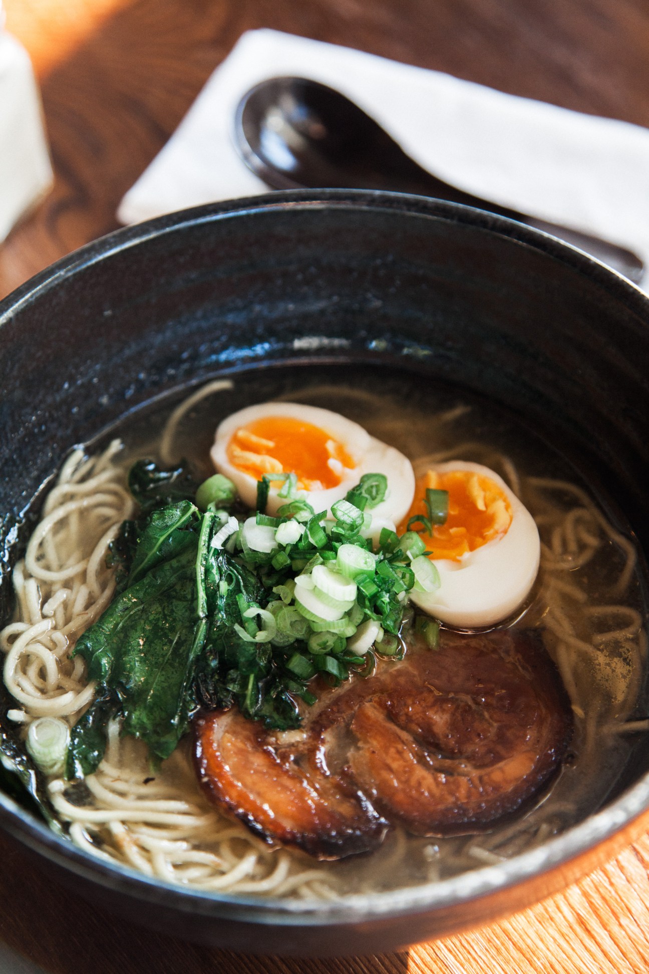 Bowl of ramen with soft-boiled egg, noodles, greens and pork from Kuma Tofino
