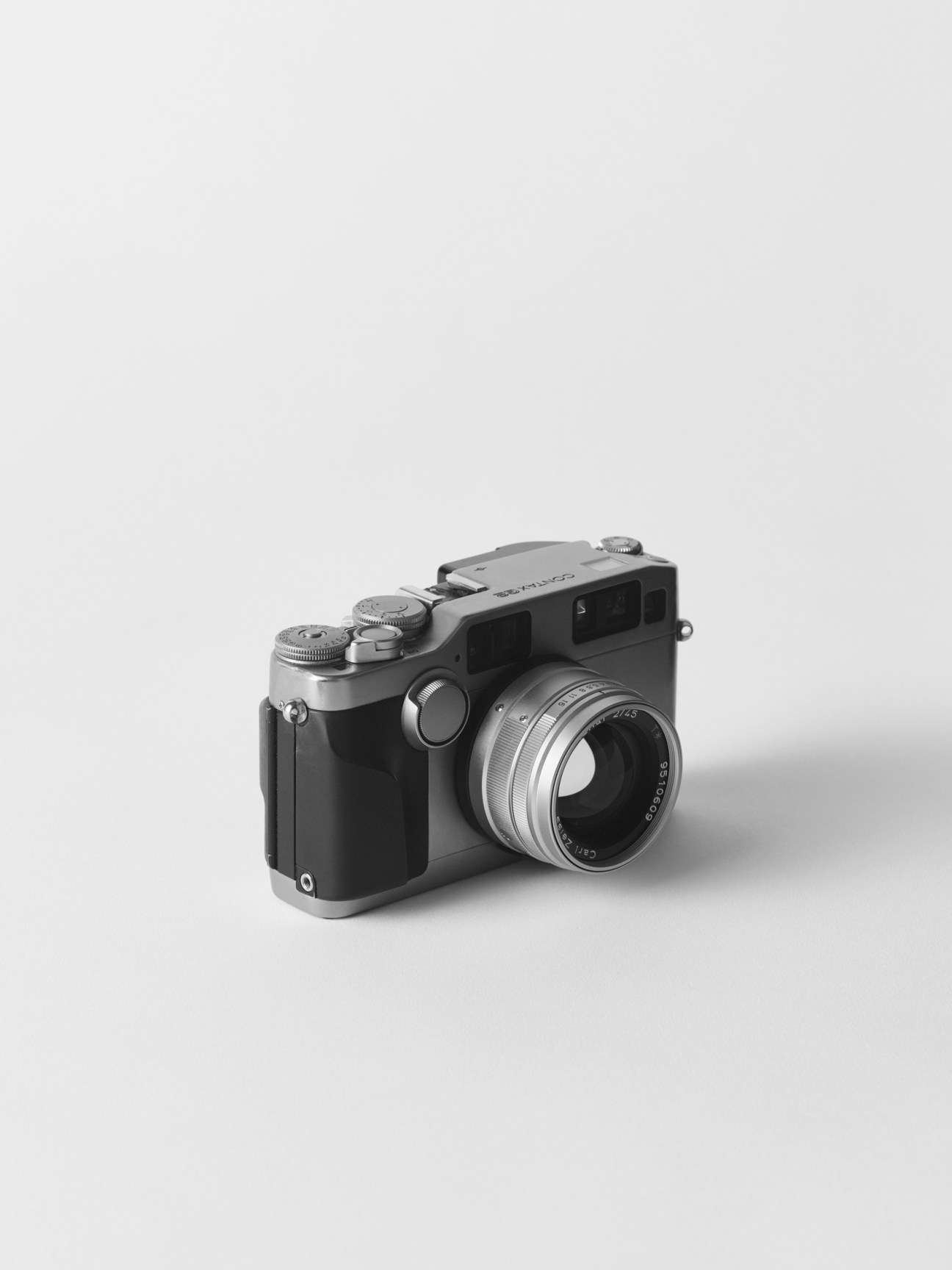 Black and white photograph of a vintage rangefinder camera with leather grip and metal lens