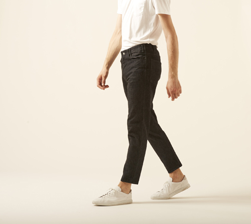 Man wearing 806t jeans by Westoveralls in indigo denim with white t-shirt and sneakers.