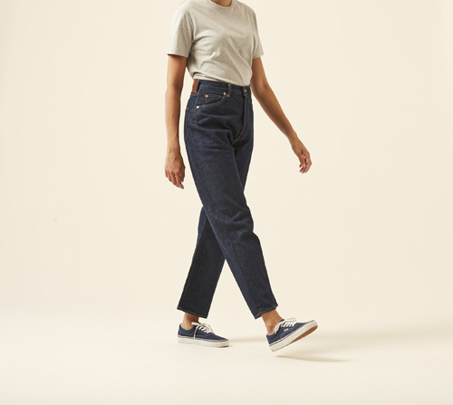 Woman wearing Monroe jeans by Chimala in raw selvedge denim with vintage-inspired fit and beige t-shirt.