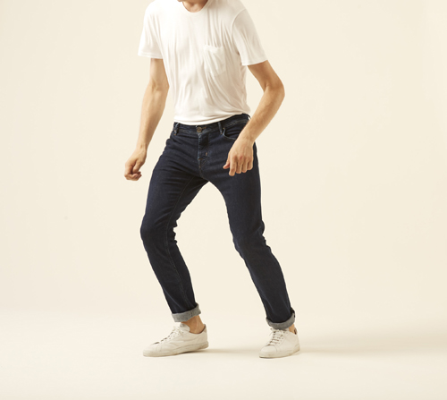 Man wearing J622 Eccellenza jeans by Jacob Cohën in dark indigo with white t-shirt and cream sneakers.