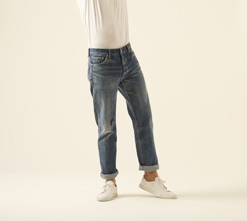 Model wearing Social sculpture dry denim-6 by Visvim with white top and cream sneakers.