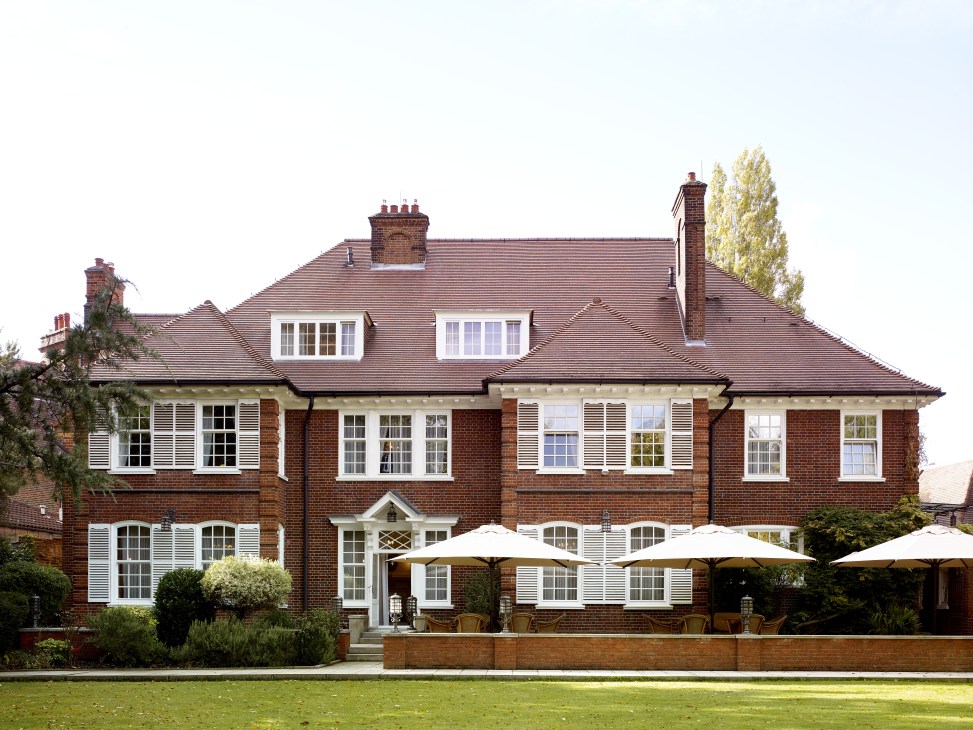 Czech ambassador's brick residence in North London with manicured garden and white umbrellas on terrace.